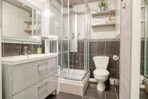 La salle de bains est pourvue de toilettes et d'une douche en verre. dans l'établissement Le 15 - Appartement pour 4 personnes - Disneyland Paris, à Esbly