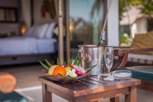 a bowl of fruit on a table with a bucket at Sarikantang Resort & Spa, Koh Phangan in Haad Rin