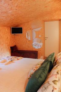 1 dormitorio con 1 cama y TV en la pared en Villa Garcia en Terras de Bouro