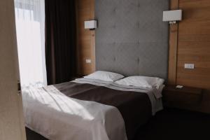 a bedroom with a large bed with white sheets at VILSON hotel in Bukovel