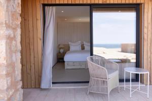 a bedroom with a bed and a table and a chair at La Tour d'Eole in Dakhla