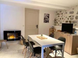 a living room with a table and chairs and a fireplace at Résidence Saint-Jean in Saint-Dalmas-le-Selvage