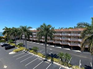an aerial view of a hotel with palm trees and a parking lot at Waterfront Resort Condo with Balcony Close to Beaches Free Bikes in Dunedin