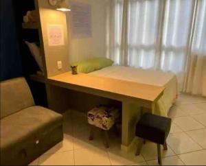 una mesa con un banco y una silla en una habitación en Apartamento quadra da praia, en Río de Janeiro