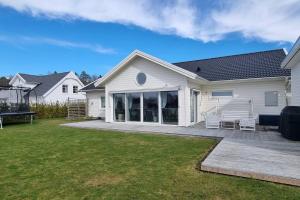 uma casa branca com um pátio e um quintal em Uthyres endast till barnfamiljer em Gullbrandstorp
