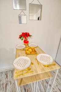 - une table en bois avec des assiettes et des fruits dans l'établissement Le 15 - Appartement pour 4 personnes - Disneyland Paris, à Esbly