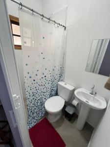 a white bathroom with a toilet and a sink at QUARTOS Praia do Tombo Guarujá in Guarujá +37 photos