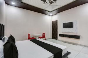 een slaapkamer met een bed en een televisie en een tafel bij OYO Flagship Hotel A&S in Rohtak