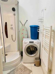 a washing machine in a bathroom with a shower at Le Viarm'Élite in Nantes