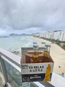 a box of beer on a balcony next to the beach at PÉ na Areia com Jacuzzi e Vista Incrível Para MAR! in Guarujá