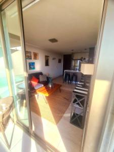 a view of a living room and a kitchen with a table at Apartamento cerca Mall Alto las Condes in Santiago