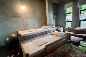 a room with two beds in a room with a couch at 2 bedroom family house in Lodge in General Luna