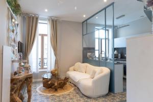 a living room with a white couch and a table at L'étoile d'Arras in Arras