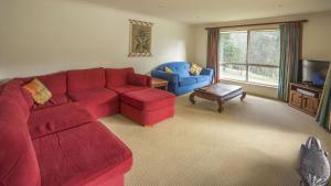 sala de estar con sofá rojo y 2 sillas azules en Atlantis on lake conjola, en Yatte Yattah