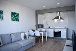 a living room with a couch and a table and a kitchen at Apartamentos Playa de Mogro in Miengo