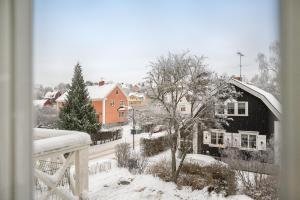 a view from a window of a snow covered house at Central beautiful modern accommodation near Stockholm City in Stockholm