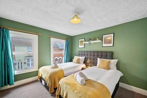 2 camas en una habitación con paredes verdes en Beautiful 2 bedroom house Free Parking, Aylesbury, Adrenham st, en Buckinghamshire