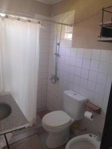 a white bathroom with a toilet and a sink at La Angelita Oeste in San Andrés de Giles