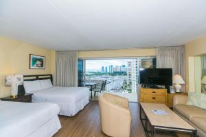 a hotel room with two beds and a couch and a tv at Ilikai Tower 1137 Yacht Harbor View 1BR in Honolulu