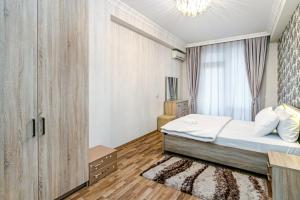 a bedroom with a bed and a large window at Vip Apartment Zara in Baku