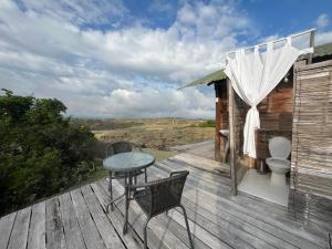 eine Terrasse mit einem Tisch, Stühlen und einem WC in der Unterkunft Hotel Flor de Liz Bereshit Bara in Villavieja