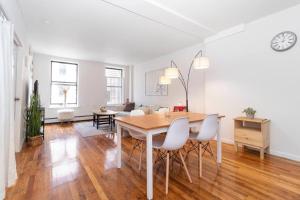 a dining room with a table and chairs in a living room at 2Bed Bliss by Central Park North in New York