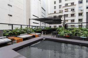 um pátio no último piso com uma piscina num edifício em Studio Lapa-Dumont Dream Suites no Rio de Janeiro
