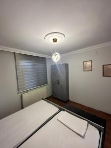 a room with a bed and a light on the ceiling at Meydan Suite Apartments in Trabzon