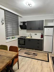 a kitchen with a wooden table and a refrigerator at Meydan Suite Apartments in Trabzon