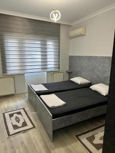 a bedroom with two beds and a window at Meydan Suite Apartments in Trabzon