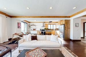 a living room with a white couch and a kitchen at Wild Horse Meadows in Eden