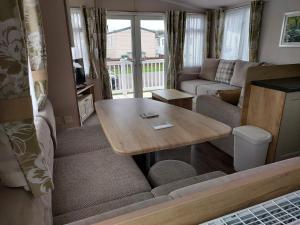 a living room with a table and a couch at 208 Holiday Resort Unity Brean 3 bed entertainment passes included in Brean