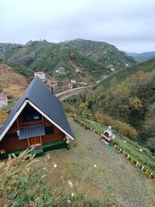 a small house with a black roof on a hill at LEROZ BUNGALOV in Cayeli