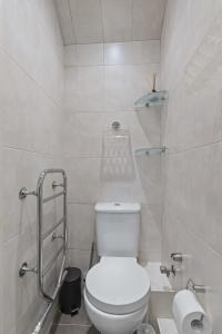 a white bathroom with a toilet and a shower at Cosy Flat In London in Ealing