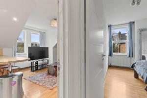 an open living room with a bed and a table at Cosy Flat In London in Ealing