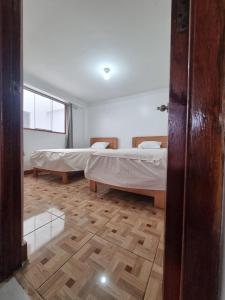 um quarto com 2 camas e piso em madeira em Casa Turismo Terres em Cusco