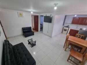 a living room with a couch and a table and a kitchen at Casa Turismo Terres in Cusco