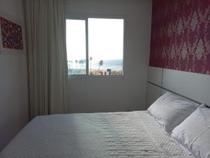 a bedroom with a bed with a view of the beach at Lindo em Pituaçu in Salvador