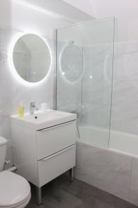 biała łazienka z umywalką i prysznicem w obiekcie Appartement entier *au pied de la gare* w mieście Juvisy-sur-Orge