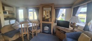 a small living room with a table and a television at Bewles Caravan in Rhyl