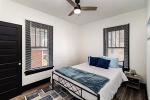 1 dormitorio con 1 cama con almohadas y ventanas azules en Sand & Sun Retreat,2 Living Rooms, Kids Play Area, en Michigan City