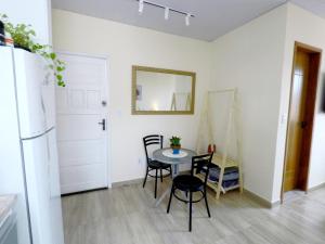 a kitchen and dining room with a table and chairs at Suítes do Cabo in Arraial do Cabo