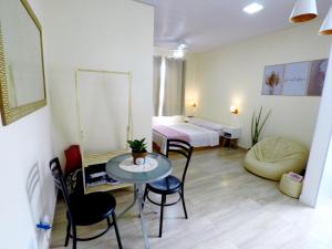 a room with a table and chairs and a bed at Suítes do Cabo in Arraial do Cabo