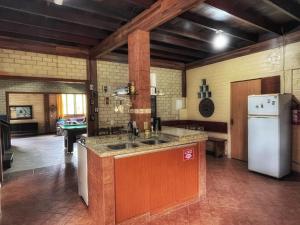 cocina con fregadero y nevera en Tô na Guarda Hostel en Palhoça
