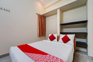 a bedroom with a large bed with red pillows at Motel Magic in Coimbatore