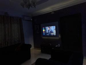 a living room with a tv in a dark room at TSOLID HOMES ( SHORTLET & APARTMENT) in Ibadan
