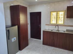 a kitchen with a refrigerator and a sink and a window at TSOLID HOMES ( SHORTLET & APARTMENT) in Ibadan