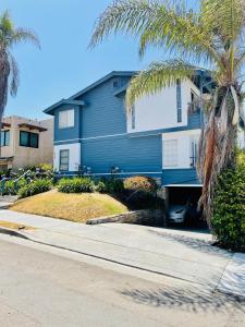 uma casa azul com palmeiras em frente a uma rua em Bonair Beach House em San Diego