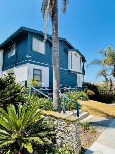uma casa azul com uma palmeira em frente em Bonair Beach House em San Diego