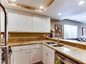 uma cozinha com armários brancos e um lavatório em Bonair Beach House em San Diego